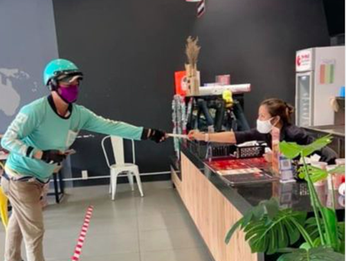 Do đó, nhiều shipper đã có sáng kiến hay để giao hàng cho khách như giữ khoảng cách trên 2m. Ảnh: Nguoiduatin.