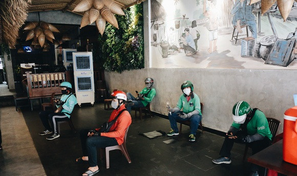 Khi chờ lấy hàng, các shipper đều giữ khoảng cách an toàn 2m. Ảnh: Cafef.