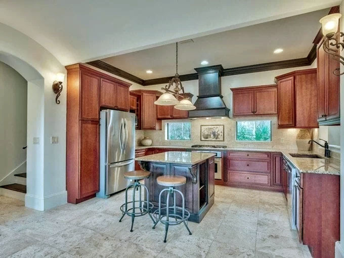 Khu bếp có sàn lát đá travertine, mặt bếp ốp đá granite và được trang bị đồ dùng tiện nghi.