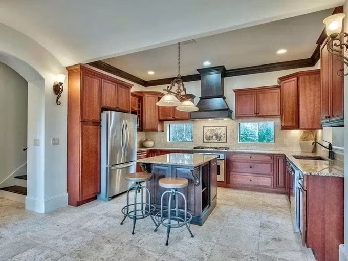 Khu bếp có sàn lát đá travertine, mặt bếp ốp đá granite và được trang bị đồ dùng tiện nghi.