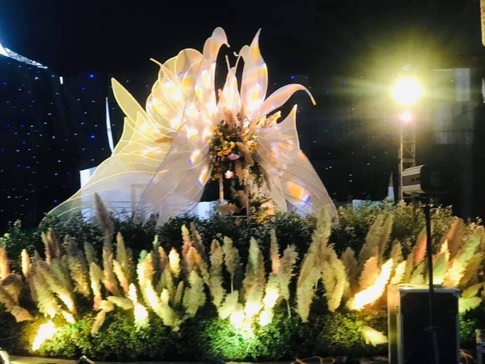 Xung quanh rạp cưới được trang trí bằng hoa tươi, và các chùm đèn led rực rỡ.