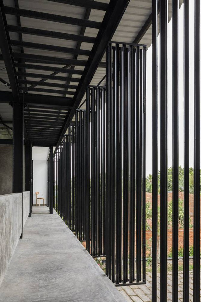Hệ thống cửa thép sơn đen bao che tất cả mặt đứng hai tầng giúp kiểm soát ánh sáng vào nhà, vừa giữ sự riêng tư.