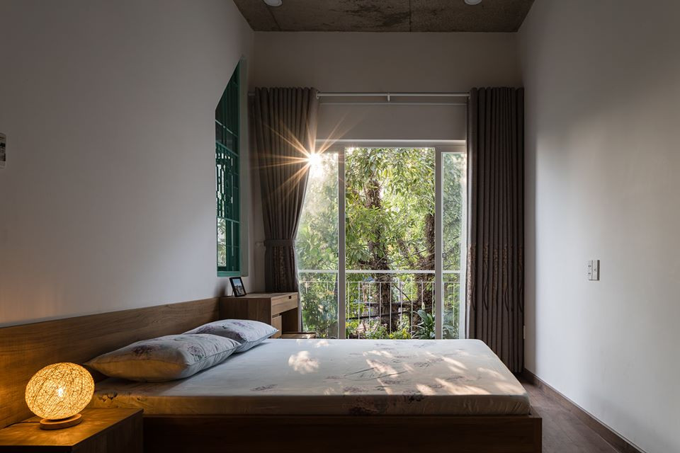 Phòng ngủ có cửa sổ lớn với tầm nhìn xanh mát.