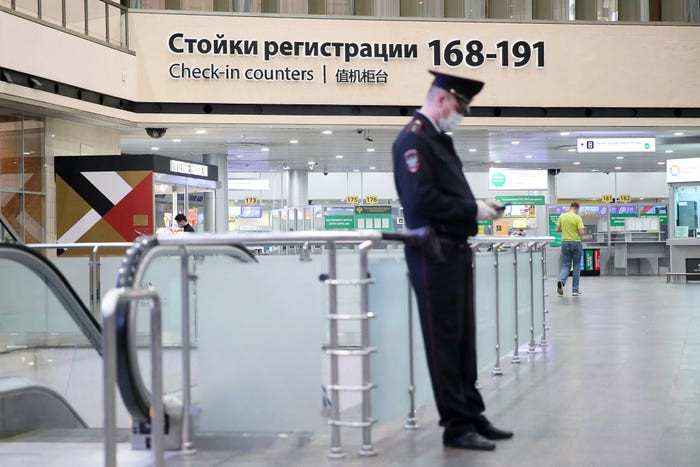 Một sĩ quan cảnh sát đeo khẩu trang y tế trong nhà ga tại sân bay quốc tế Sheremetyevo ở Nga.