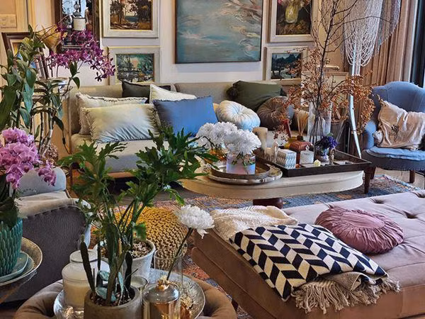 Tại phòng khách, nhà thiết kế nổi tiếng lựa chọn bộ sofa có gam màu lạnh kết hợp với nhiều loại cây và hoa.