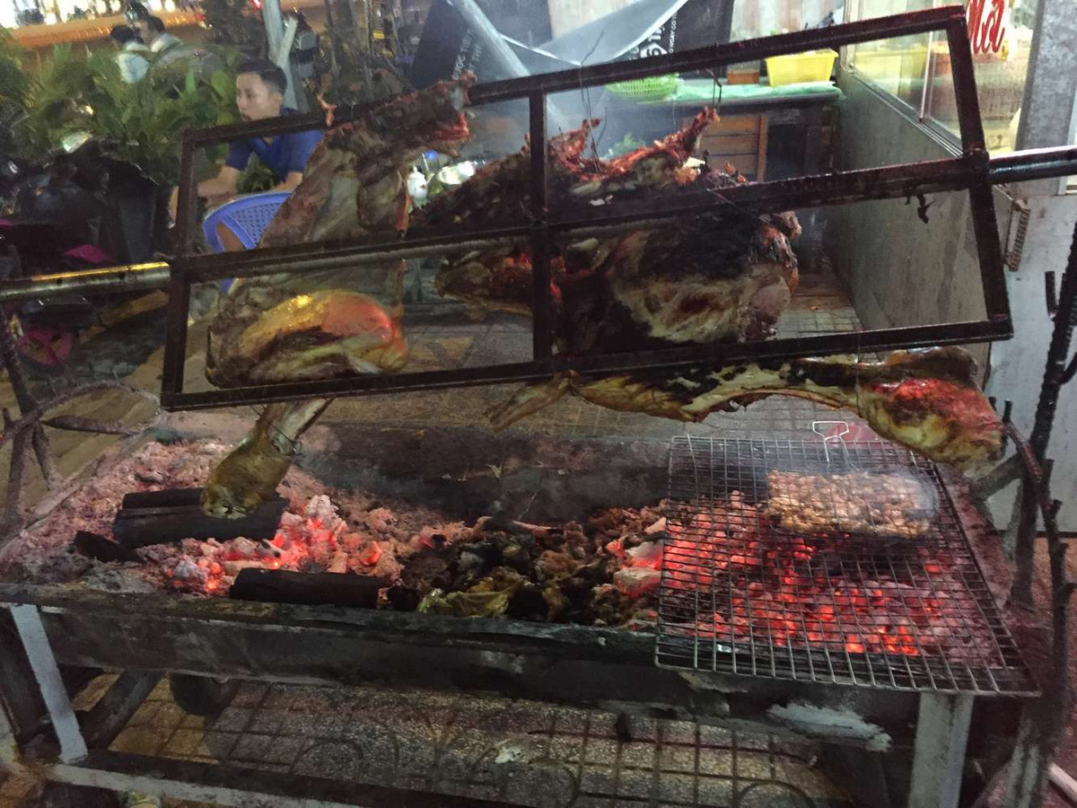 Con bò lăn trong một cây trục, hai đầu gác lên hai trụ bằng tre, được quay chầm chậm liên tục trên lửa than cháy riu riu.