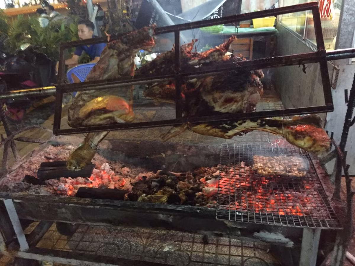 Con bò lăn trong một cây trục, hai đầu gác lên hai trụ bằng tre, được quay chầm chậm liên tục trên lửa than cháy riu riu.