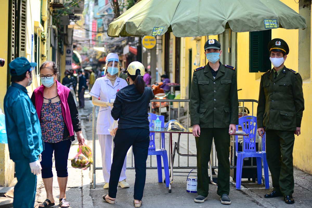 Để đảm bảo an toàn trong mùa dịch COVID-19, phố Yên Thái đã thực hiện kẻ vạch, đo nhiệt độ và yêu cầu người dân khử khuẩn tay trước khi vào chợ thực hiện mua bán. Ảnh: Baotintuc.