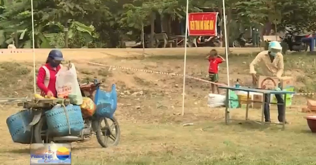 Hàng hóa, nhu yếu phẩm được người bán gói ghém sẵn, chất lên bàn, sau đó lùi lại. Ảnh cắt video VTV.