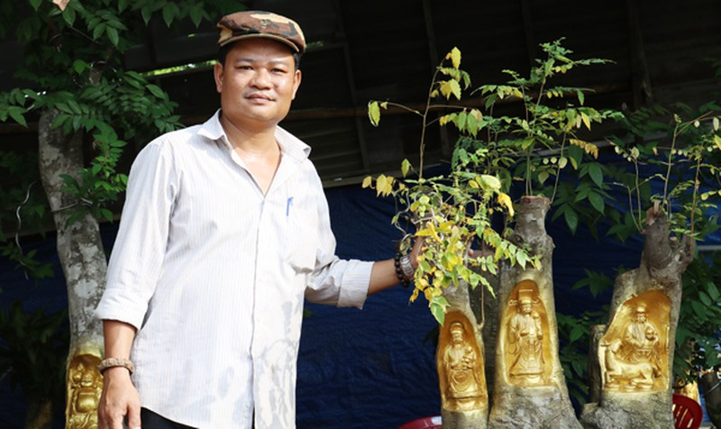 Dưới bàn tay tài hoa của anh Trần Quốc Việt (Cái Răng, Cần Thơ), những bức tượng Phúc Lộc Thọ, Thần Tài, Thổ Địa... được điêu khắc và “dát vàng” trên thân cây hết sức sống động. Ảnh: Baophapluat.