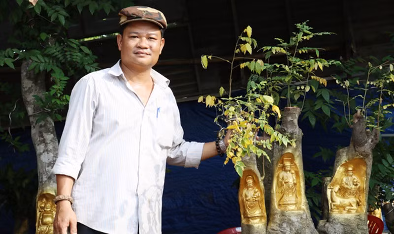 Dưới bàn tay tài hoa của anh Trần Quốc Việt (Cái Răng, Cần Thơ), những bức tượng Phúc Lộc Thọ, Thần Tài, Thổ Địa... được điêu khắc và “dát vàng” trên thân cây hết sức sống động. Ảnh: Baophapluat.