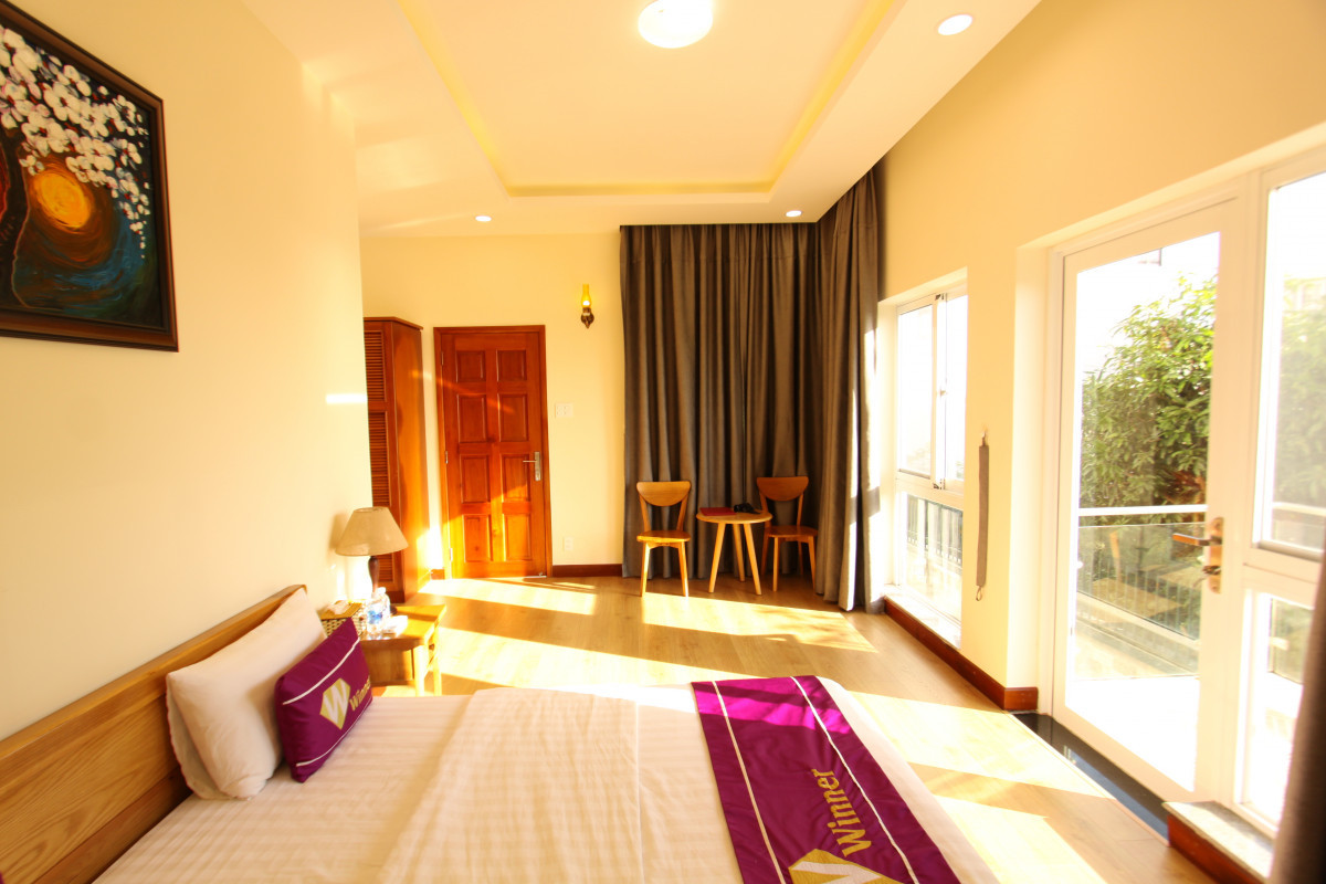 Phòng ngủ có ban công và view ra vườn cây xanh mướt. Ảnh: Luxstay.