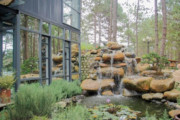 Phía trước biệt thự có hồ nước nhỏ trồng những khóm cây nhỏ xanh mướt mắt, chẳng khác nào một khu nghỉ dưỡng. Ảnh: GDTĐ.