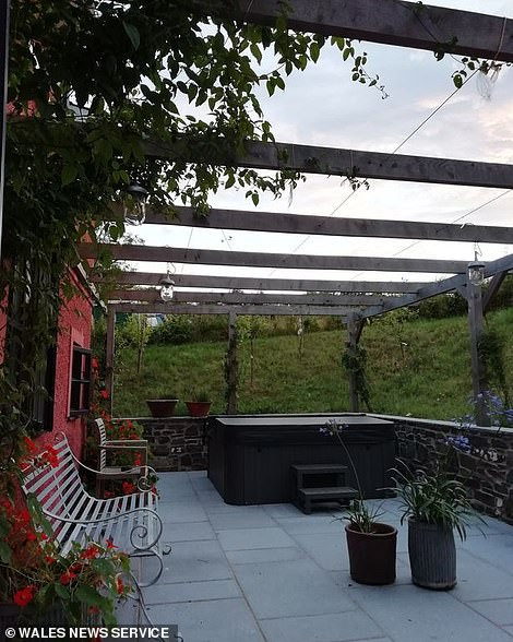 Hiên sau nhà có một bồn nước nóng thư giãn.