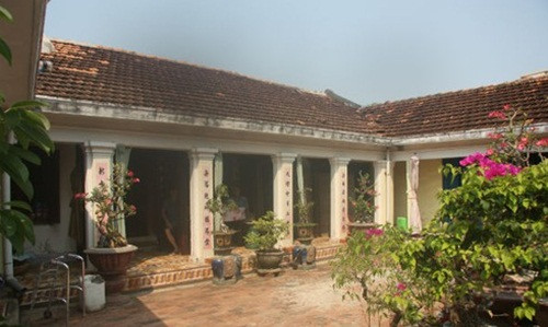 Đây là ngôi nhà của nghệ nhân Võ Hiển Đạt. Nhà cổ thiết kế 3 gian chính với 24 cột gỗ theo kiểu “nhà rường đắp đất” cùng cột kèo “rau muống” chạm hình đầu rồng hoặc đầu chim phụng. Ảnh: Infonet.