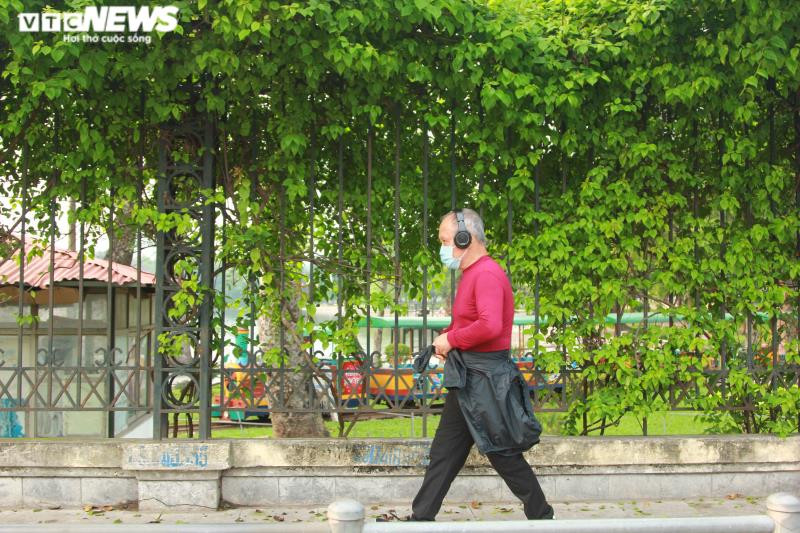 Người đàn ông đeo khẩu trang, vừa nghe nhạc vừa đi bộ.