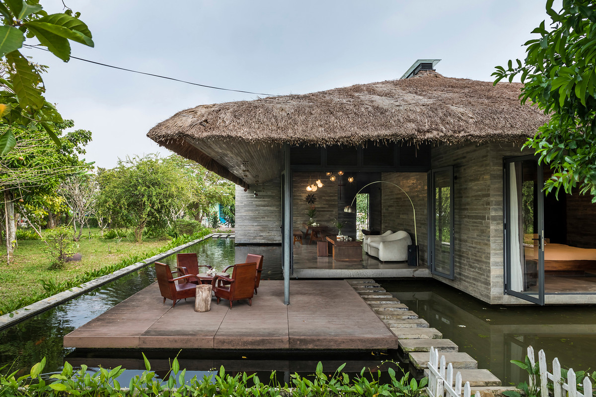 Căn nhà được thiết kế với 5 khối riêng biệt, bố trí ngẫu nhiên dưới một mái tranh lớn và ngay bên cạnh một hồ nước.