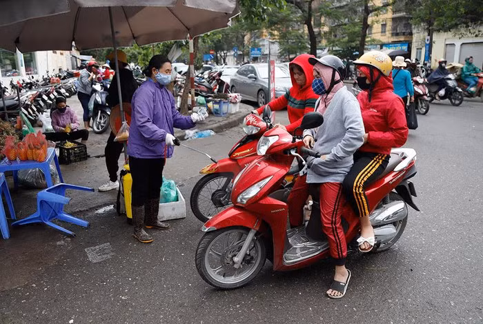 Trước đó, ngày 31-3, Thủ tướng Chính phủ Nguyễn Xuân Phúc ban hành Chỉ thị số 16/CT-TTg về các biện pháp cấp bách phòng, chống dịch Covid-19 nhằm giảm thiểu nguy cơ lây nhiễm cộng đồng. Trong ảnh: Nhân viên phun thuốc khử trùng các phương tiện trước khi vào chợ mua hàng.