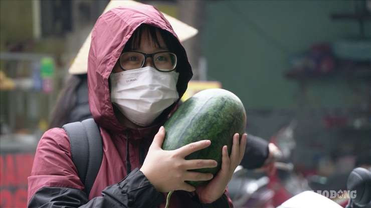 Nhiều người dân cũng tranh thủ mua dưa hấu vì vừa có hoa quả rẻ ăn lại giúp được người nông dân. Ảnh: Lao động.