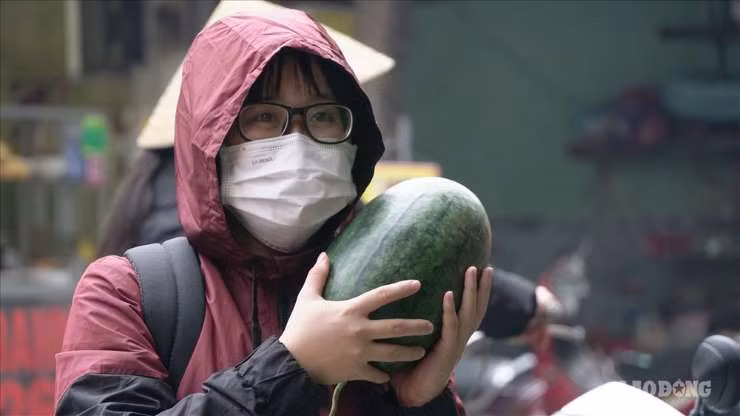 Nhiều người dân cũng tranh thủ mua dưa hấu vì vừa có hoa quả rẻ ăn lại giúp được người nông dân. Ảnh: Lao động.