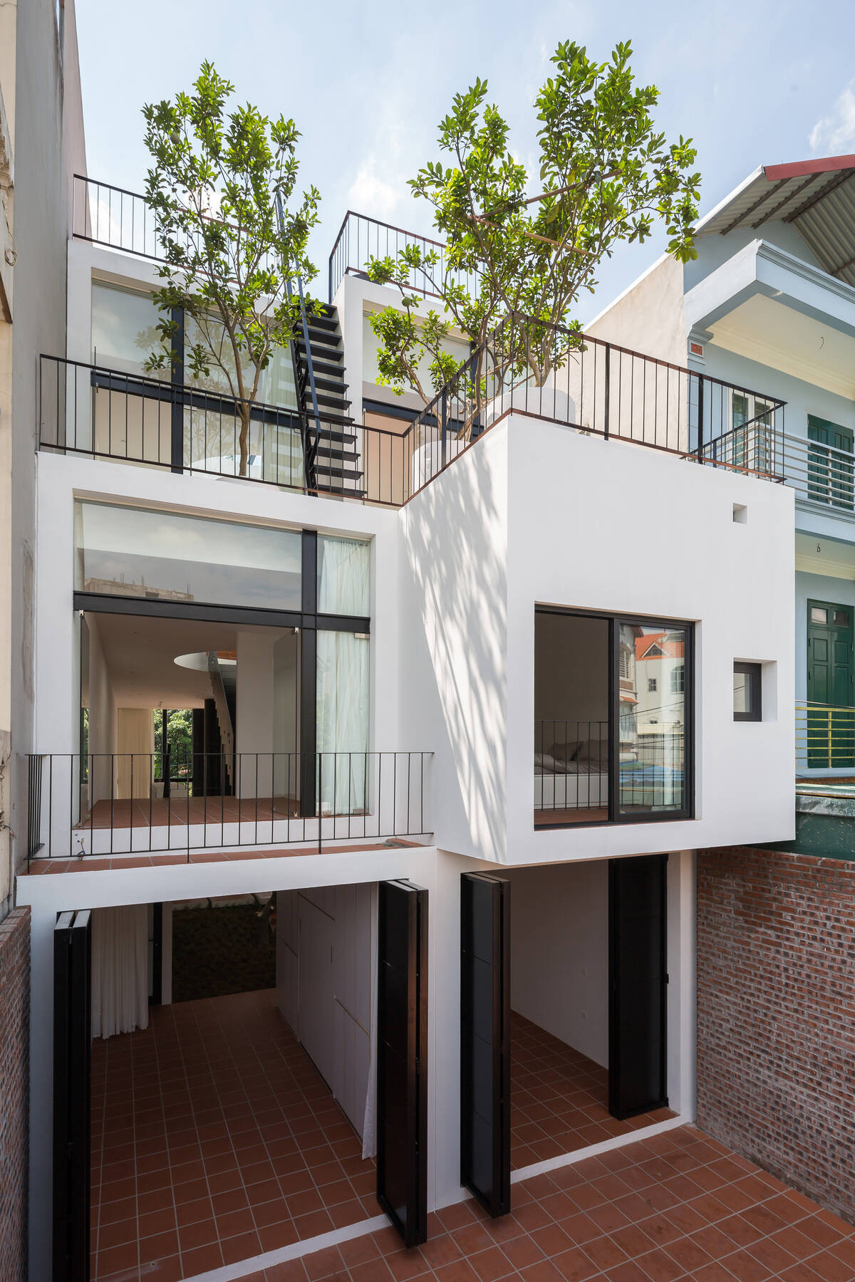 Khu đất xây dựng được bố mẹ chia đôi cho hai anh em trai theo chiều dọc. Tuy nhiên, thay vì xây 2 căn riêng biệt, nhóm kiến trúc sư đã thiết kế hai hệ kết cấu, hai hệ thống điện, nước cho hai nửa khu đất nhưng tổng thể vẫn là một ngôi nhà.