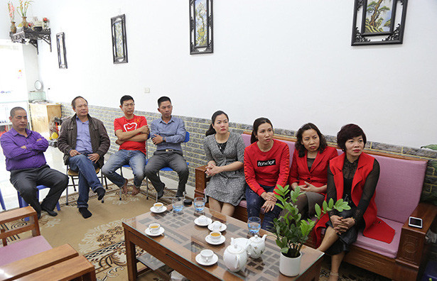 Phòng khách có màu trắng chủ đạo, bộ sofa gỗ đơn giản và tô điểm xanh bởi vài chậu cây cảnh. Ảnh: Nhadeptv.