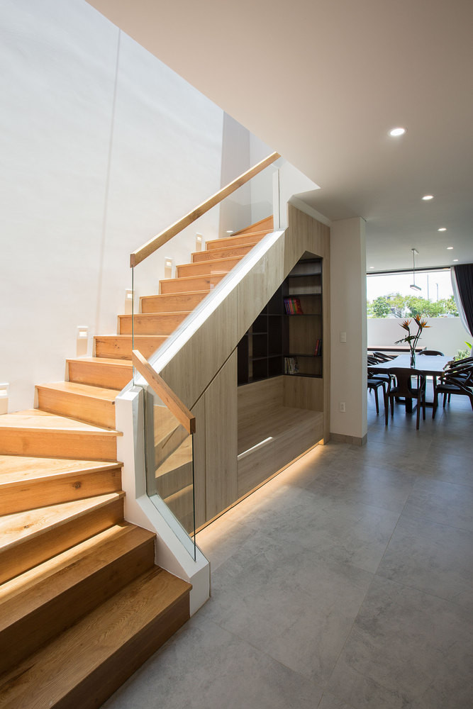 Ngay khi bạn bước qua cửa chính, một cầu thang được dẫn lên lên tầng 2 và các kiến trúc sư đã tận dụng các không gian dưới cầu thang để trang trí kệ.