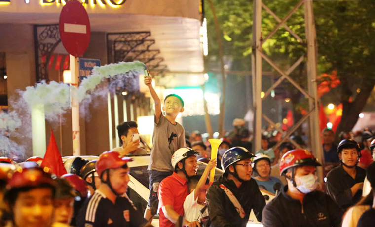 Trẻ nhỏ cùng cùng người lớn đổ xuống đường mừng chiến thắng của Đội tuyển bóng đá nước nhà.