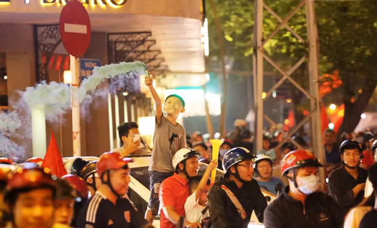 Trẻ nhỏ cùng cùng người lớn đổ xuống đường mừng chiến thắng của Đội tuyển bóng đá nước nhà.