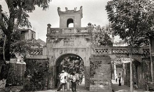 Ông John Ramsden đã đến và sinh sống ở Việt Nam những năm 1980 – 1983 khi đảm nhiệm vị trí Phó đại sứ Anh tại Hà Nội. Trong thời gian ở đây, nhà ngoại giao này đã chụp được hơn 1.800 bức ảnh về thủ đô Hà Nội cũng như cuộc sống của người dân ở mảnh đất ngàn năm văn hiến. Trong ảnh là cửa Ô Quan Chưởng ở đầu phố Hàng Chiếu sầm uất người qua lại.