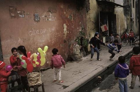 Trẻ em chơi đùa vui vẻ trên hè phố dịp Tết âm lịch.