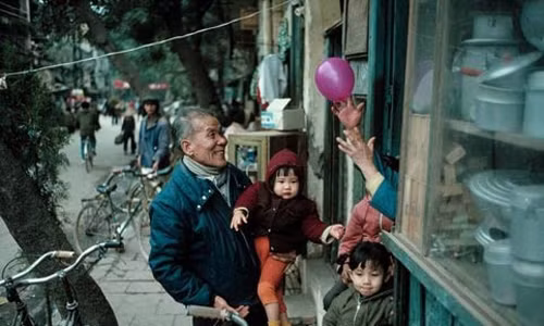 Hình ảnh ấm áp ông bế cháu đi chơi trong dịp Tết âm lịch.