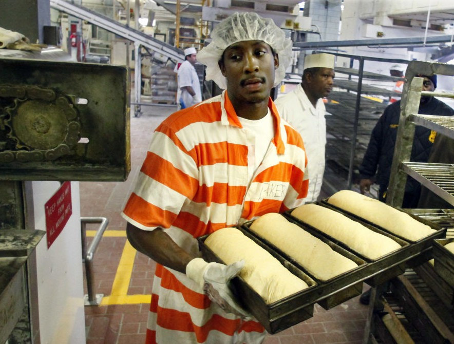 Tù nhân Nikos Alexis cho bột vào lò nướng ở tiệm bánh trong nhà tù Rikers Island. Anh ta là thành viên của một nhóm gồm 20 tù nhân có thể kiếm được một ít tiền nhờ việc nướng hàng ngàn ổ bánh mì cho số lượng lớn tù nhân. Được biết, năm 2011 có khoảng 13.000 tù nhân nam, nữ bị giam trong nhà tù này.