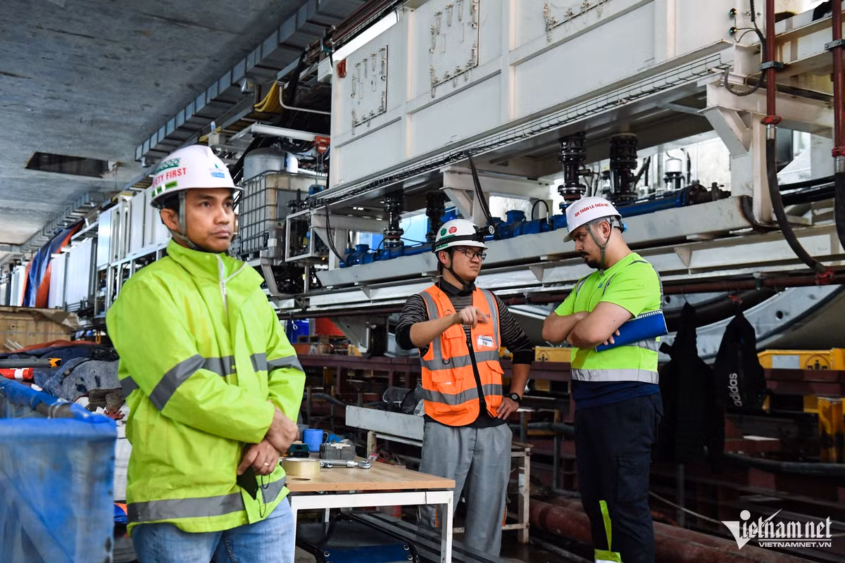Đội ngũ kỹ thuật vận hành máy đào thứ 2 thuộc tuyến metro Nhổn - ga Hà Nội trao đổi và quan sát những mũi khoan đầu tiên của TBM2. Việc thi công khoan hầm được tiến hành với sự thận trọng và giám sát nghiêm ngặt, bảo đảm an toàn cho các công trình trên mặt đất và tiến độ đề ra.