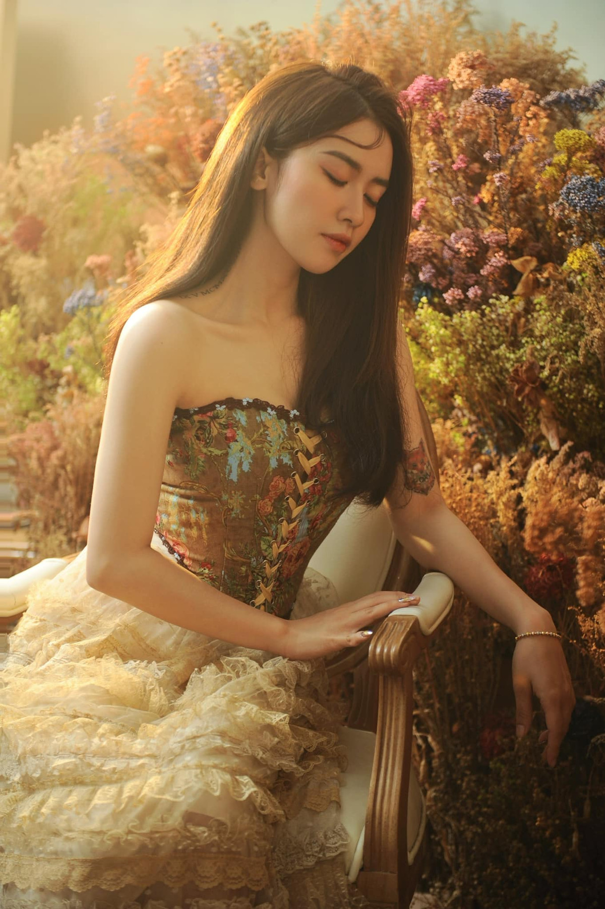 Quyên Qui đã lựa chọn một bộ cánh có phần trên là áo ôm sát khoe được những đường cong hoàn hảo và bờ vai trần gợi cảm, còn phần dưới là chân váy bồng bềnh xếp tầng với nhiều chất liệu vải khác nhau tạo nên cảm giác dịu dàng, nữ tính.