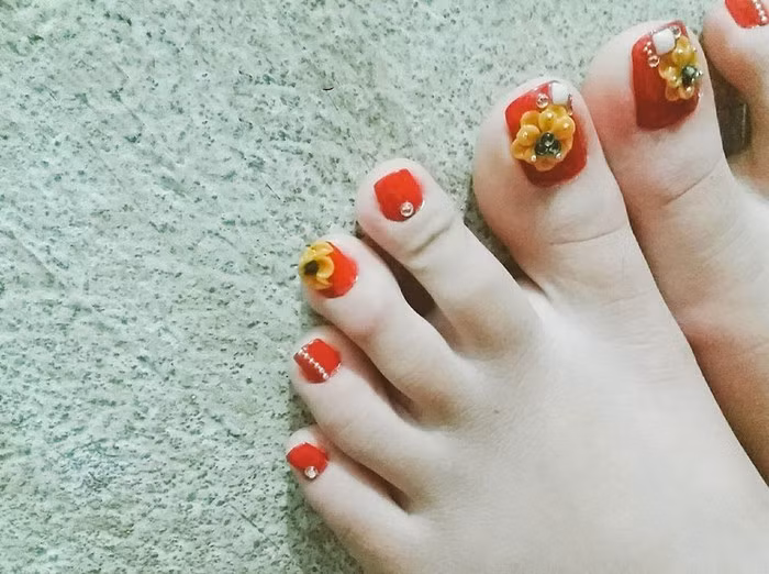 Bộ nail này ngoài nhược điểm trông "hơi quê" thì thực sự chỉ cần khoe chân thế này thôi đã thấy không khí Tết rồi.