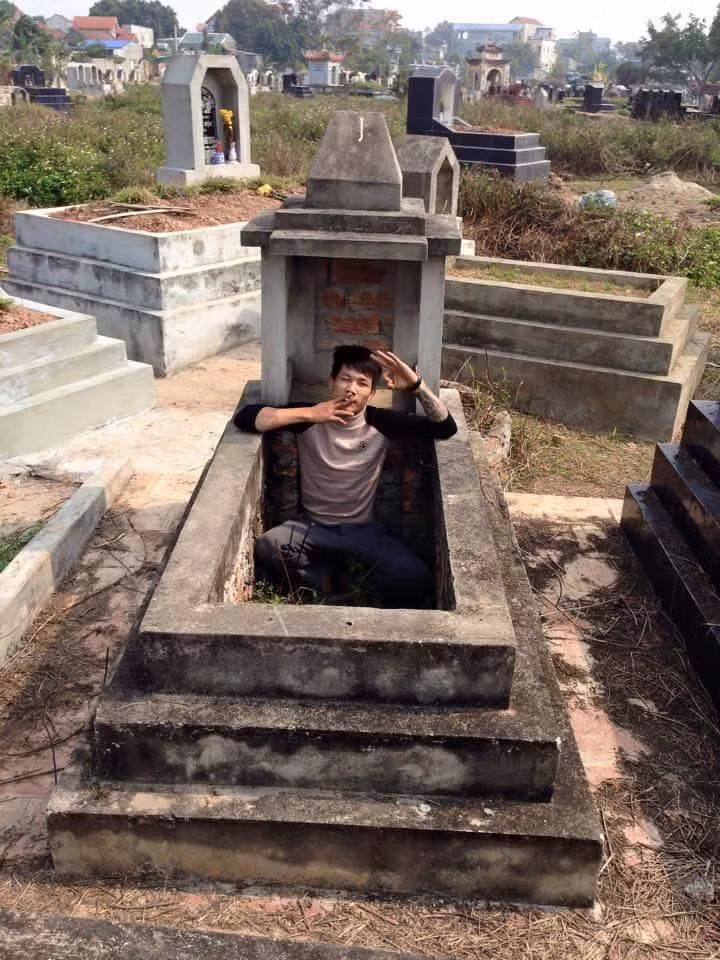 Hành động trèo hẳn vào bên trong ngôi mộ của thanh niên trong tấm ảnh này thật sự rất khó chấp nhận và còn khiến những người chứng kiến lạnh xương sống vì độ táo tợn, bất chấp tất cả để có được tấm ảnh "khác người" của một bộ phận giới trẻ ngày nay.