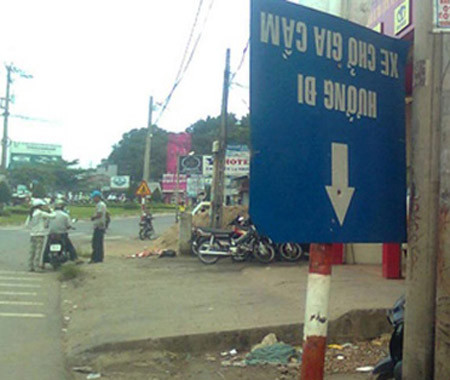 Một tấm biển bị xoay ngược lại, không thể đọc được nội dung...