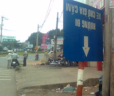 Một tấm biển bị xoay ngược lại, không thể đọc được nội dung...