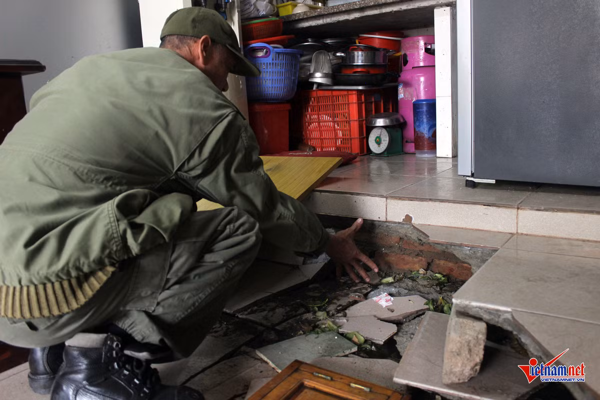 Ông Phạm Văn Hoan dùng tay đo khoảng cách nền bị lún.