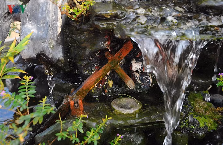 Một chiếc cối giã gạo ẩn mình sau thác nước róc rách.