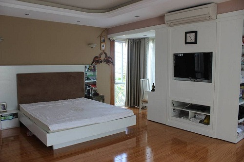 Phòng ngủ chính của vợ chồng anh Mỹ lấy màu trắng làm chủ đạo, kệ tủ áp tường 3 chiều thông minh sử dụng cho nhu cầu giải trí và làm việc. Ảnh: Khám phá.