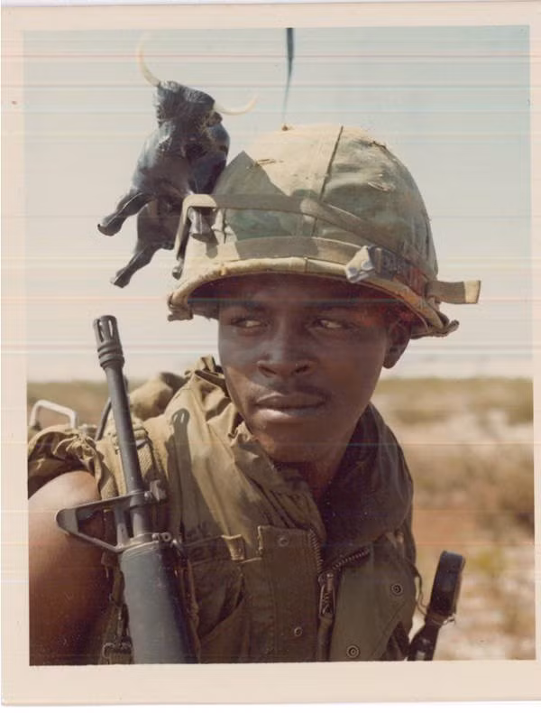 Một lính Mỹ trang trí chiếc mũ của mình bằng một con trâu nhựa.