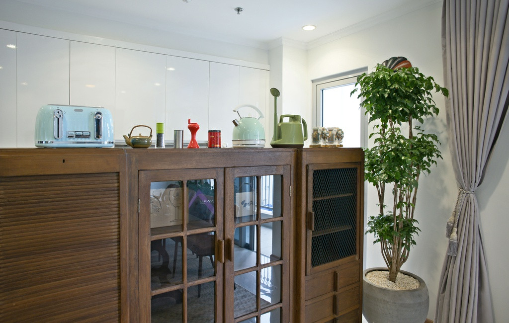 Kệ tủ được trang trí thêm bằng các vật dụng nhỏ xinh, đáng yêu. Các vật dụng phòng ăn từ chất liệu gỗ cũng làm tăng tính hoài cổ của căn hộ.