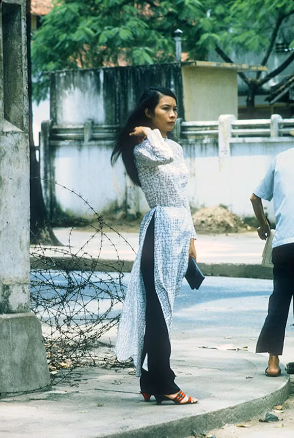 Người đẹp áo dài làm bừng sáng góc phố mang bầu không khí u ám của thời chiến. Ảnh: Cwbarrett.com.