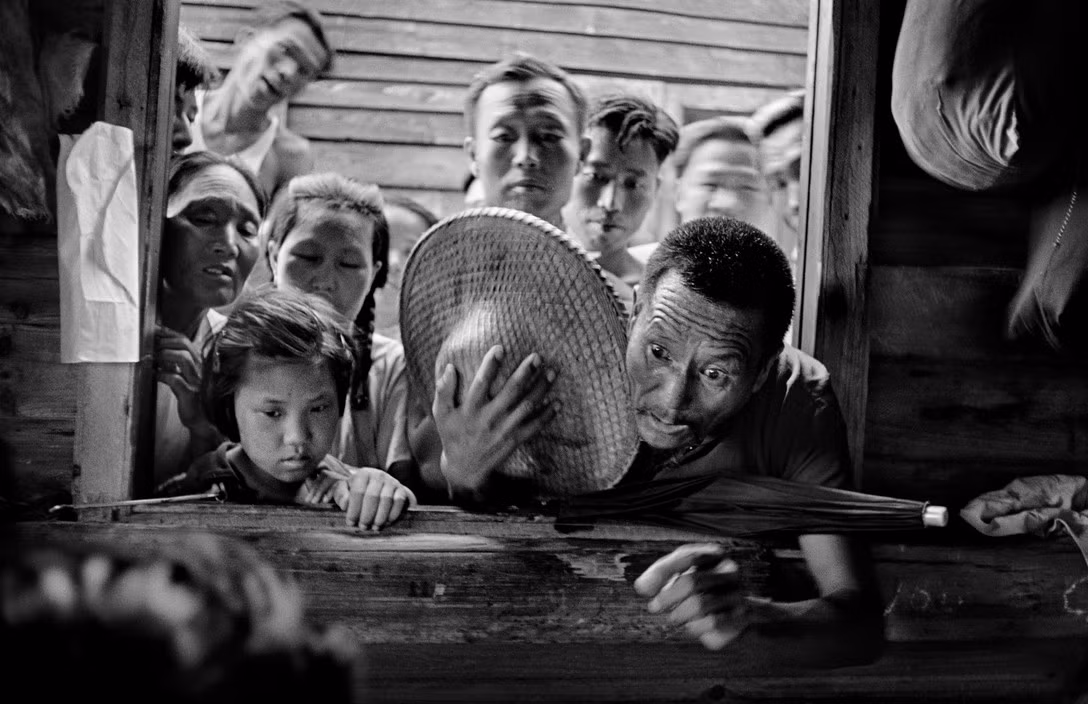 Người tản cư Hoa lục tụ tập ngoài quầy phát tem phiếu thực phẩm ở Hong Kong năm 1952. Ảnh: Werner Bischof/ Magnum Photos.