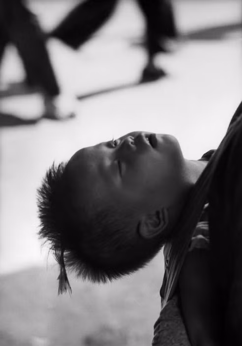 Giấc ngủ trên lưng mẹ của một em bé di tản từ Đại lục. Ảnh: Werner Bischof/ Magnum Photos.