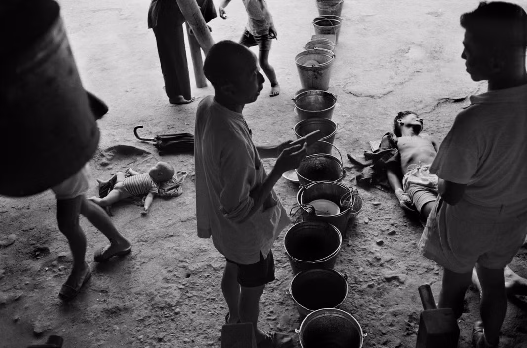 Những người tản cư chờ lấy nước tại vòi công cộng ở trại tạm cư. Ảnh: Werner Bischof/ Magnum Photos.