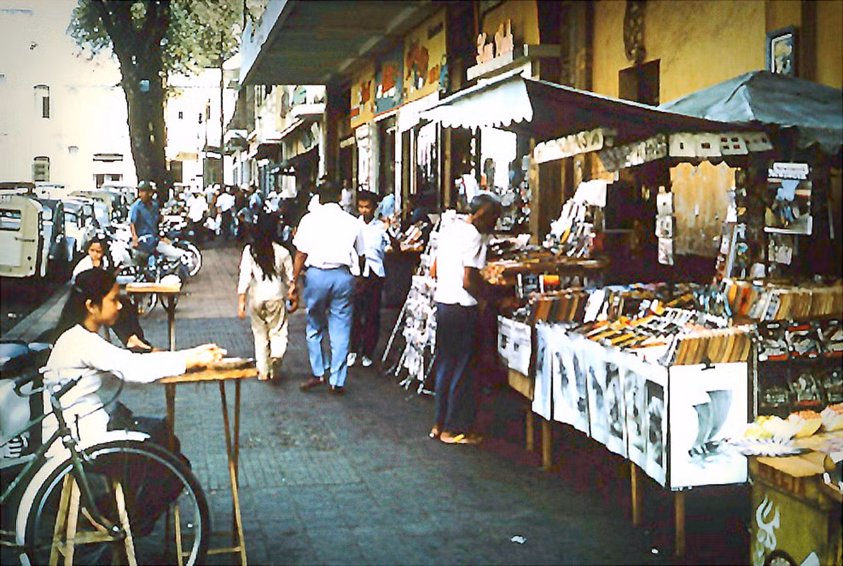 Các quầy hàng lưu niệm trên vỉa hè đại lộ Lê Lợi, đối diện rạp Rex. Ảnh: Cwbarrett.com.