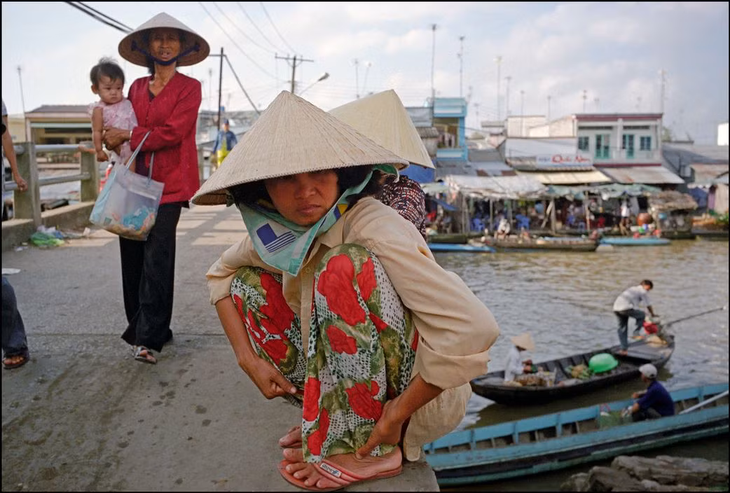 Trên một cây cầu bắc qua rạch Bảo Định ở thành phố Mỹ Tho, Tiền Giang. Ảnh: Ian Berry/ Magnum Photos.